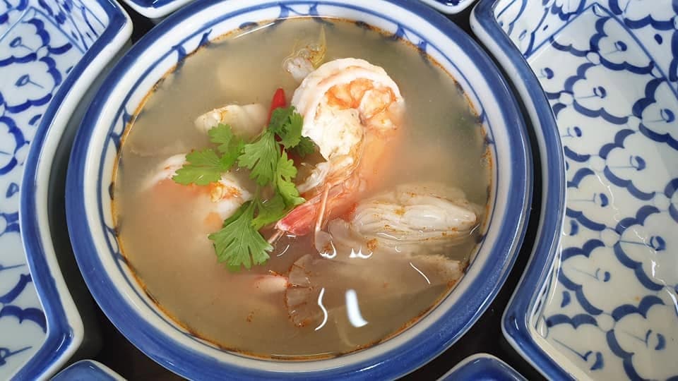 A bowl of tom yum with prawns, chilli and coriander.