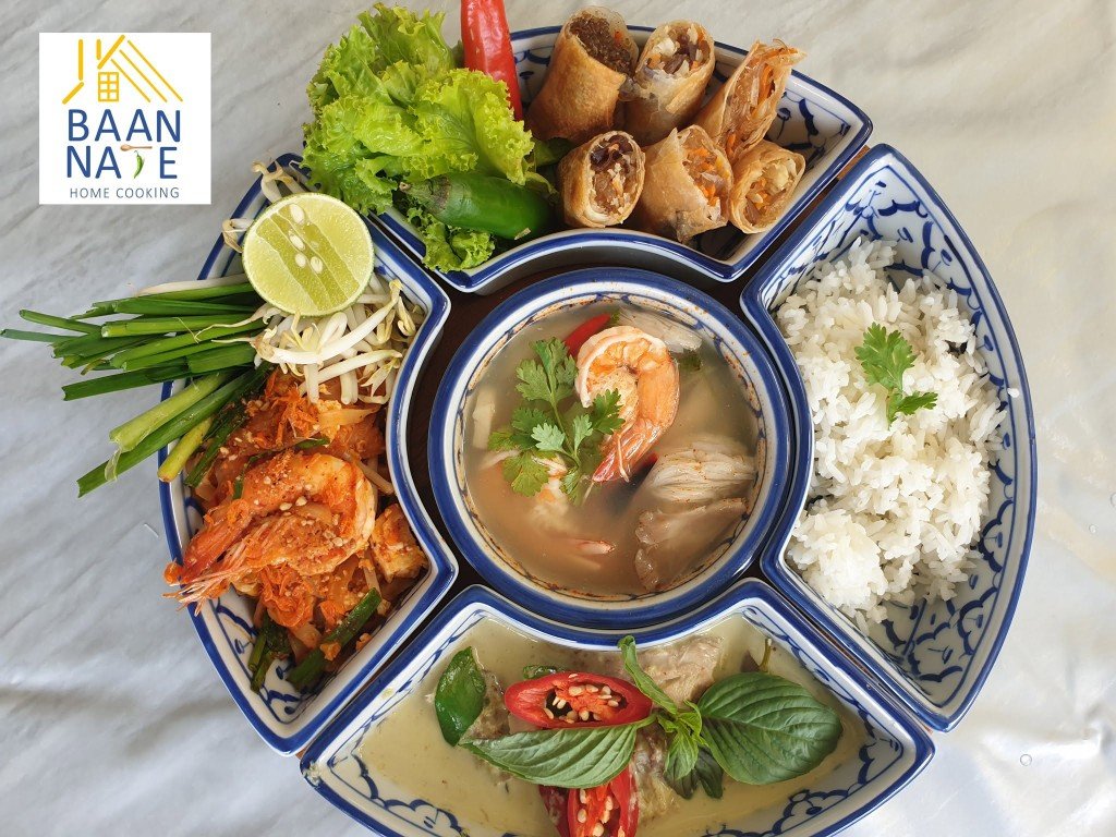 A shared tray of tom yum, pad thai, rice, green curry, herbs and spring rolls.